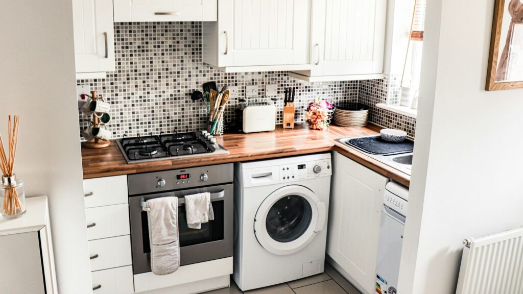Kleine keuken indelen met compacte opstelling, wasmachine onder werkblad en efficiënt gebruik van ruimte